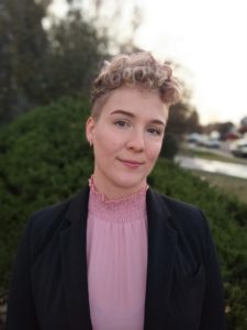 photo of woman with short blond hair, pink shirt, and black blazer